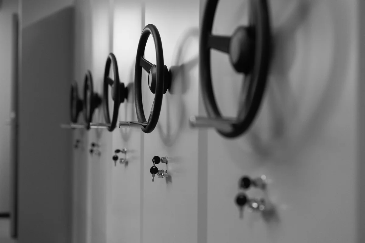 Hand-wheels and key locks on a row of mobile archive shelving units, in black and white