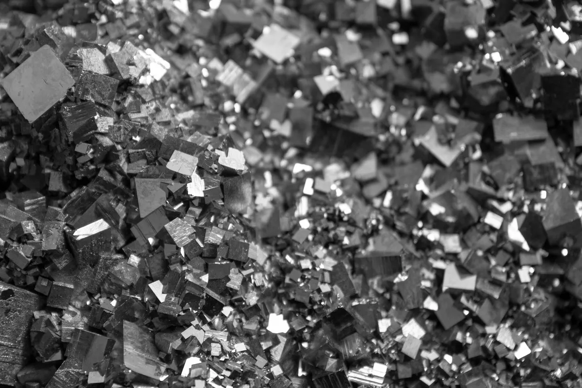 Close-up pyrite crystals, metallic facets arranged irregularly, black-and-white photograph