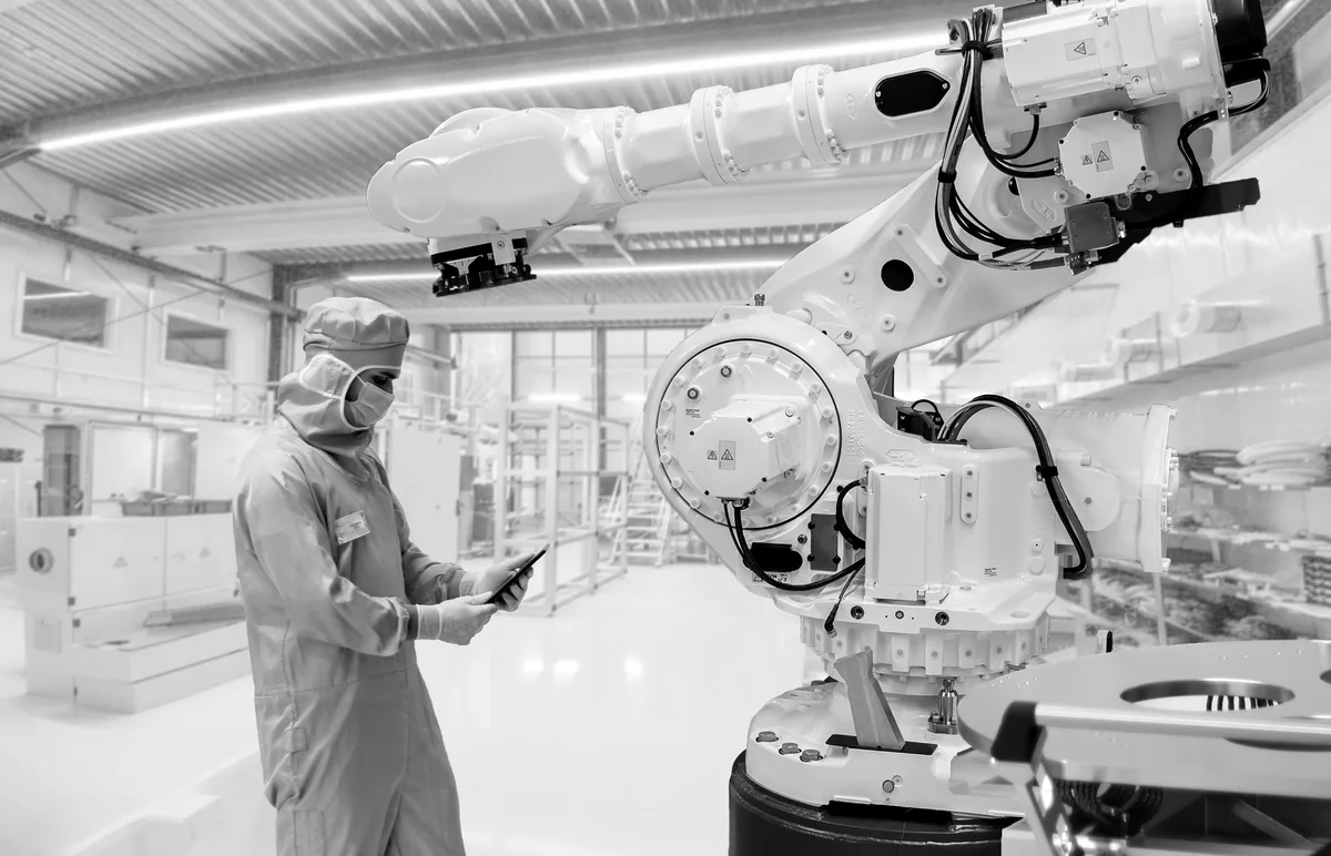 Industrial robotic arm with an operator checking its data