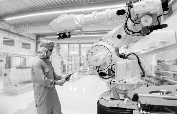 Industrial robotic arm with an operator checking its data