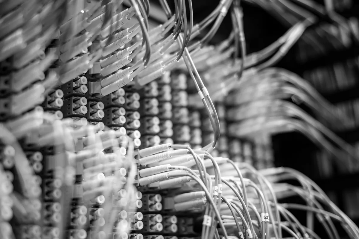 Pannello di permutazione con decine di cavi in fibra ottica collegati in un data center