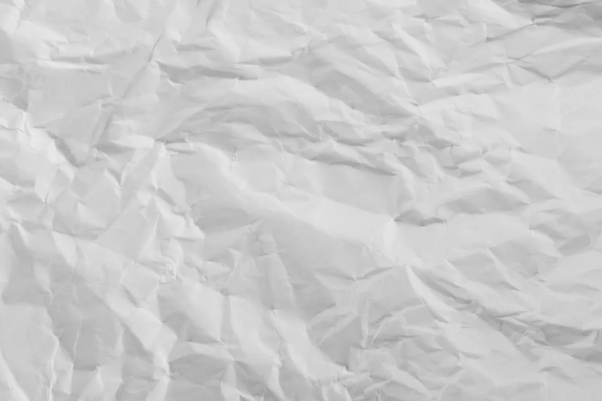 Crumpled blank sheet of white paper photographed close up, black and white, no writing or people