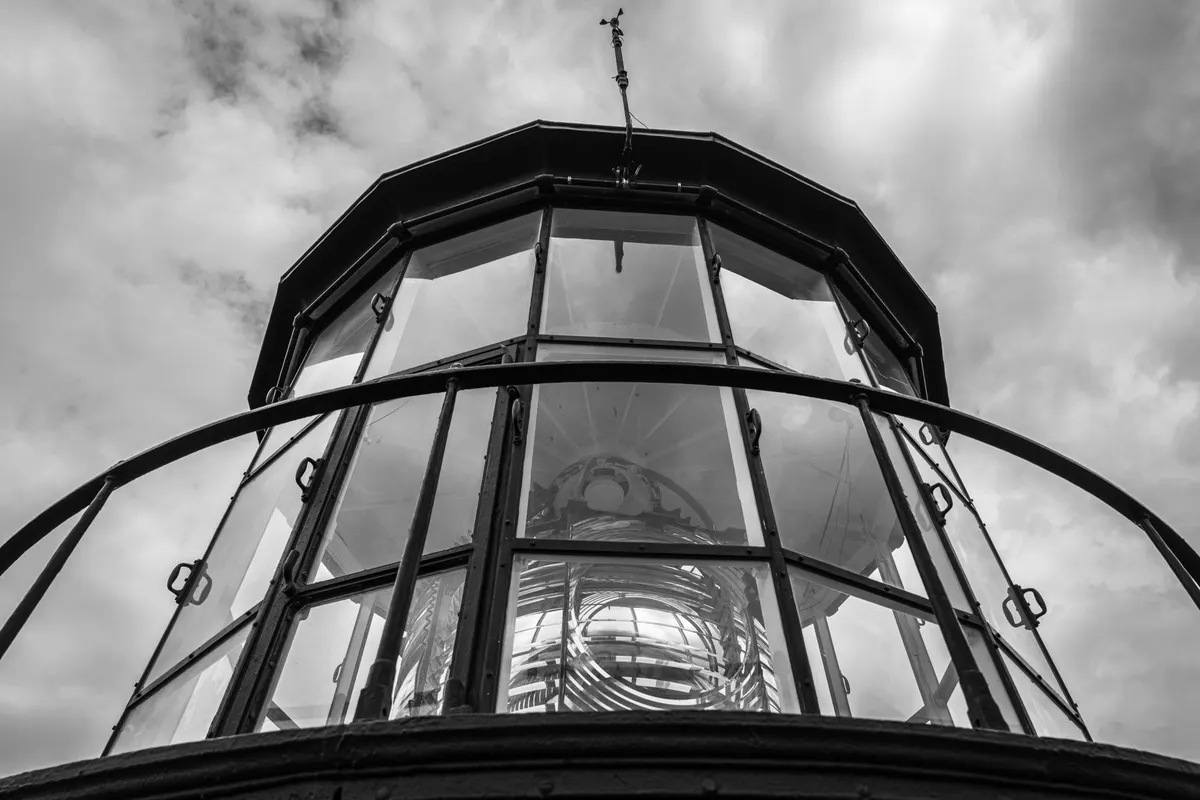 A lighthouse lantern seen from below, the Fresnel lens behind the glazing