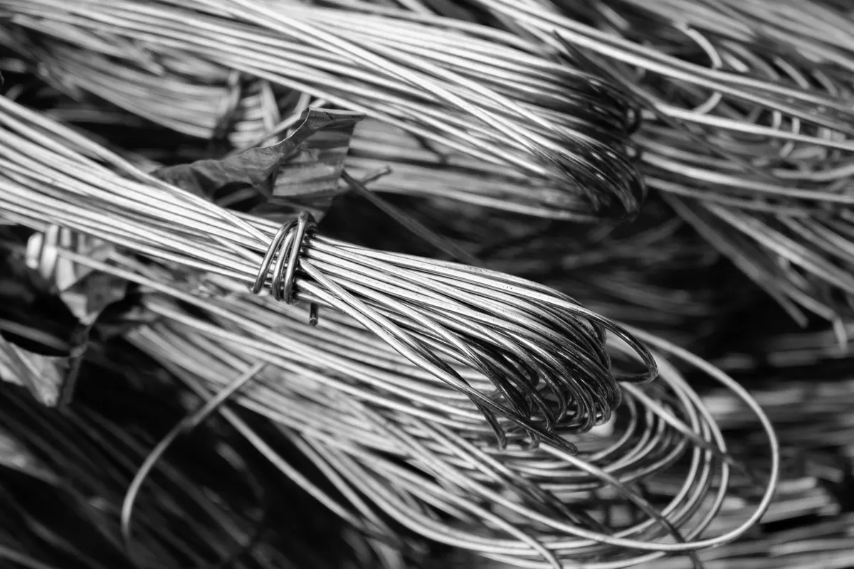 Bundles of copper wire tied and stacked, shot close up, black and white photograph