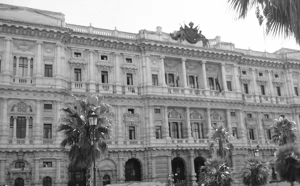 Monumental facade of the Palace of Justice in Rome, with palm trees in backlight