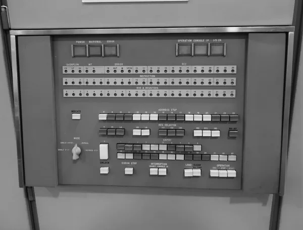 Control panel of a vintage computer with rows of switches and error indicator lights
