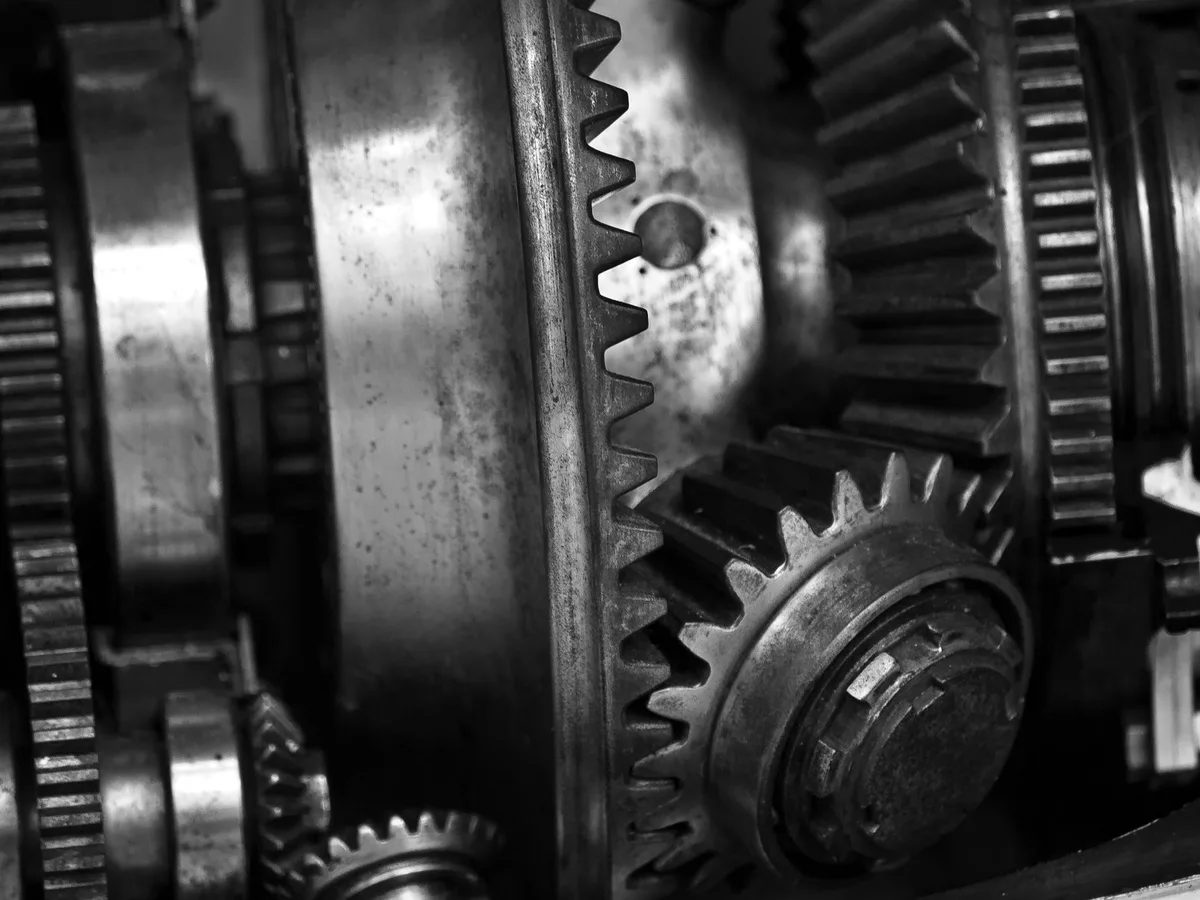 Industrial metal gears meshing together, shot close up, in black and white