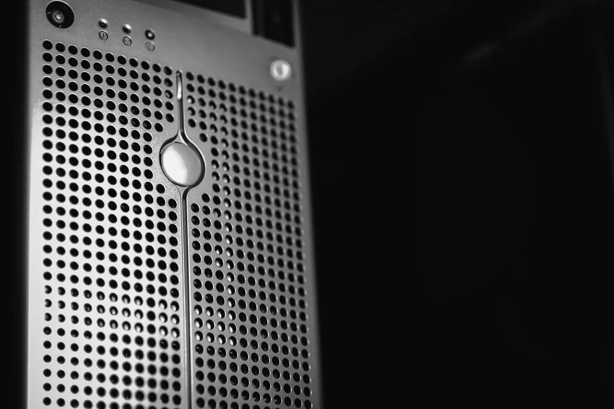 Perforated panel of a server case with a lit indicator light, in black and white