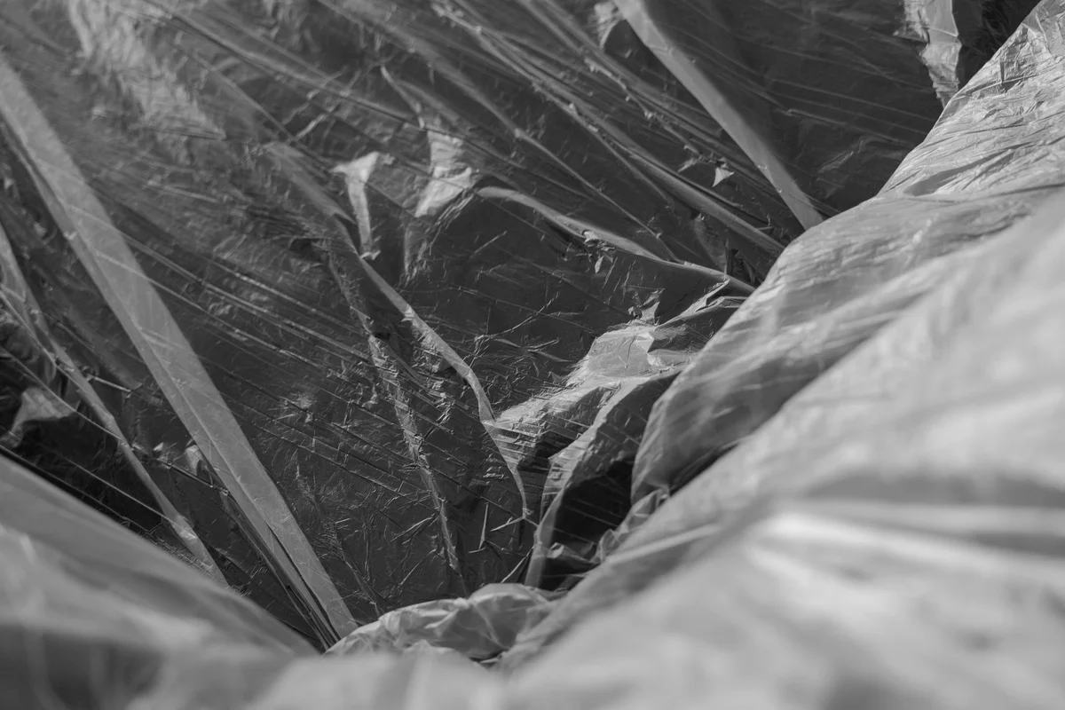 Stretch film wrapped around a pallet, photographed close up: folds and reflections in black and white
