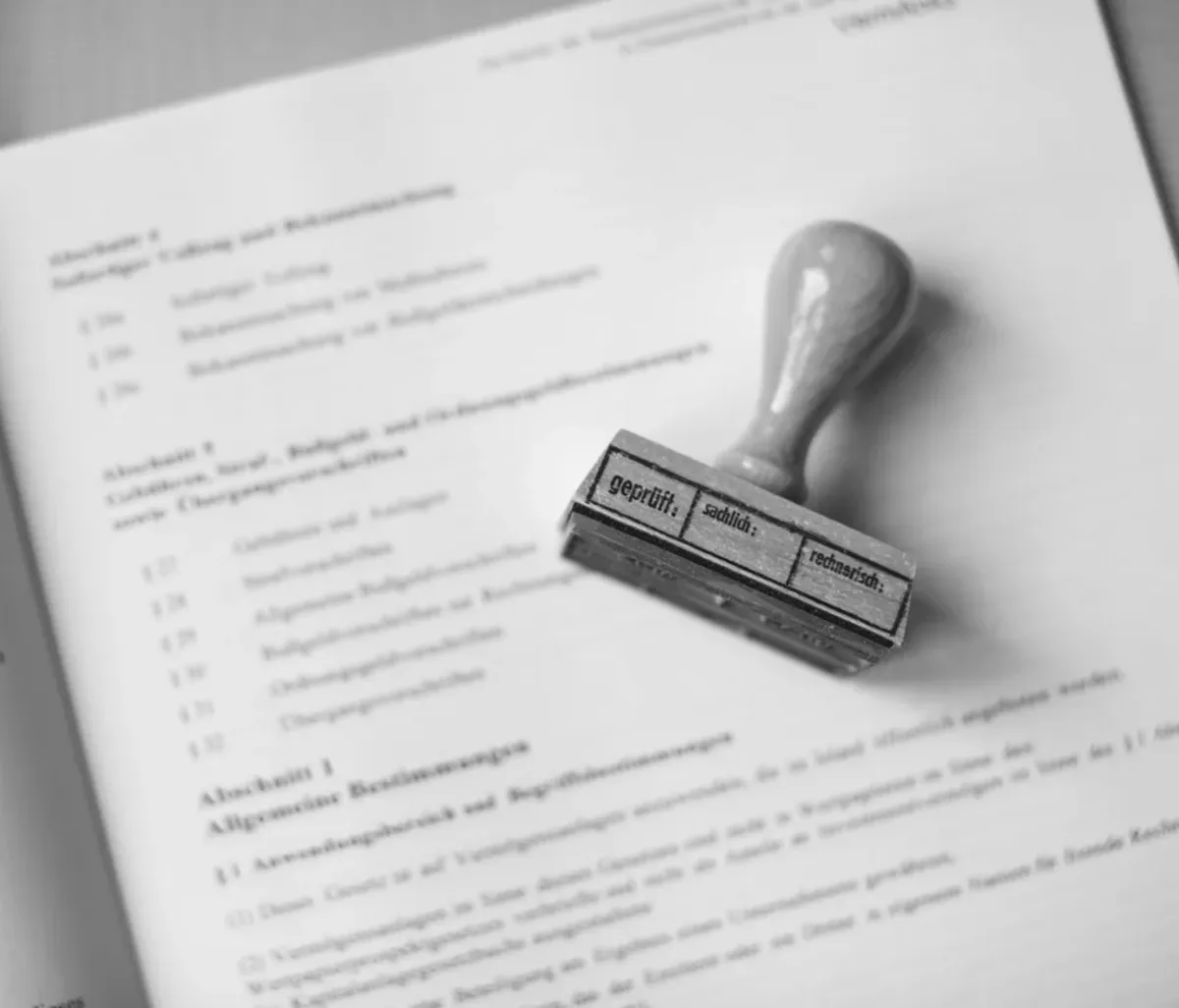 Timbro di verifica su un testo di legge aperto, appoggiato su una pagina stampata