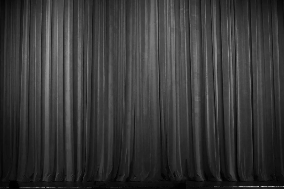 Sipario rosso di teatro, chiuso, fotografato di fronte, in bianco e nero